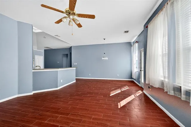 a view of a bedroom with wooden floor and a ceiling fan