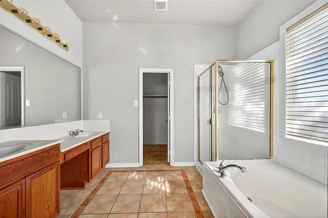 a bathroom with a granite countertop tub sink and mirror