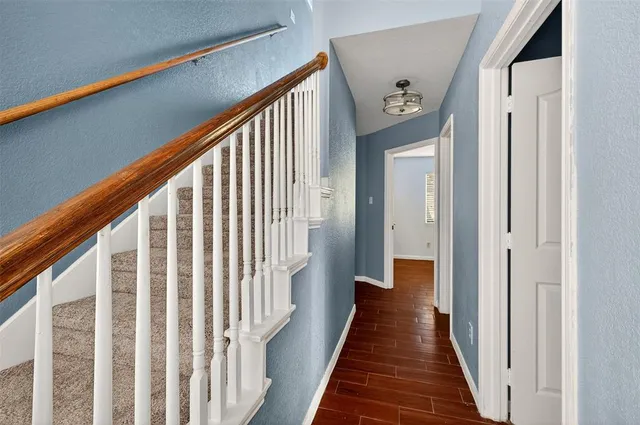 a view of a hallway with wooden floor and staircase