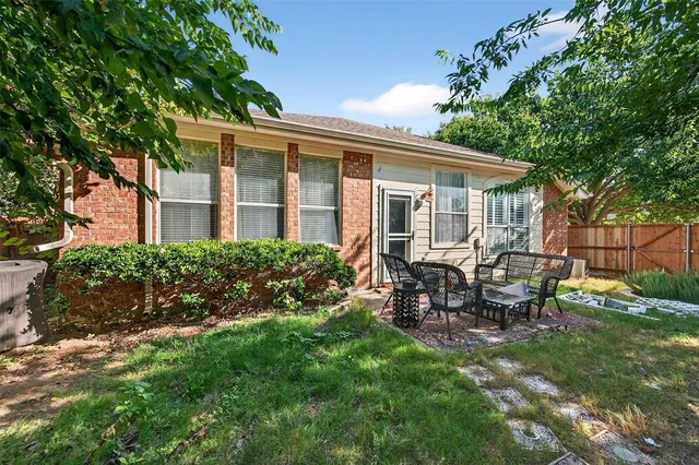 a view of a house with backyard and sitting area