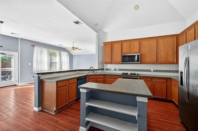 a kitchen with stainless steel appliances granite countertop a stove a sink and a refrigerator