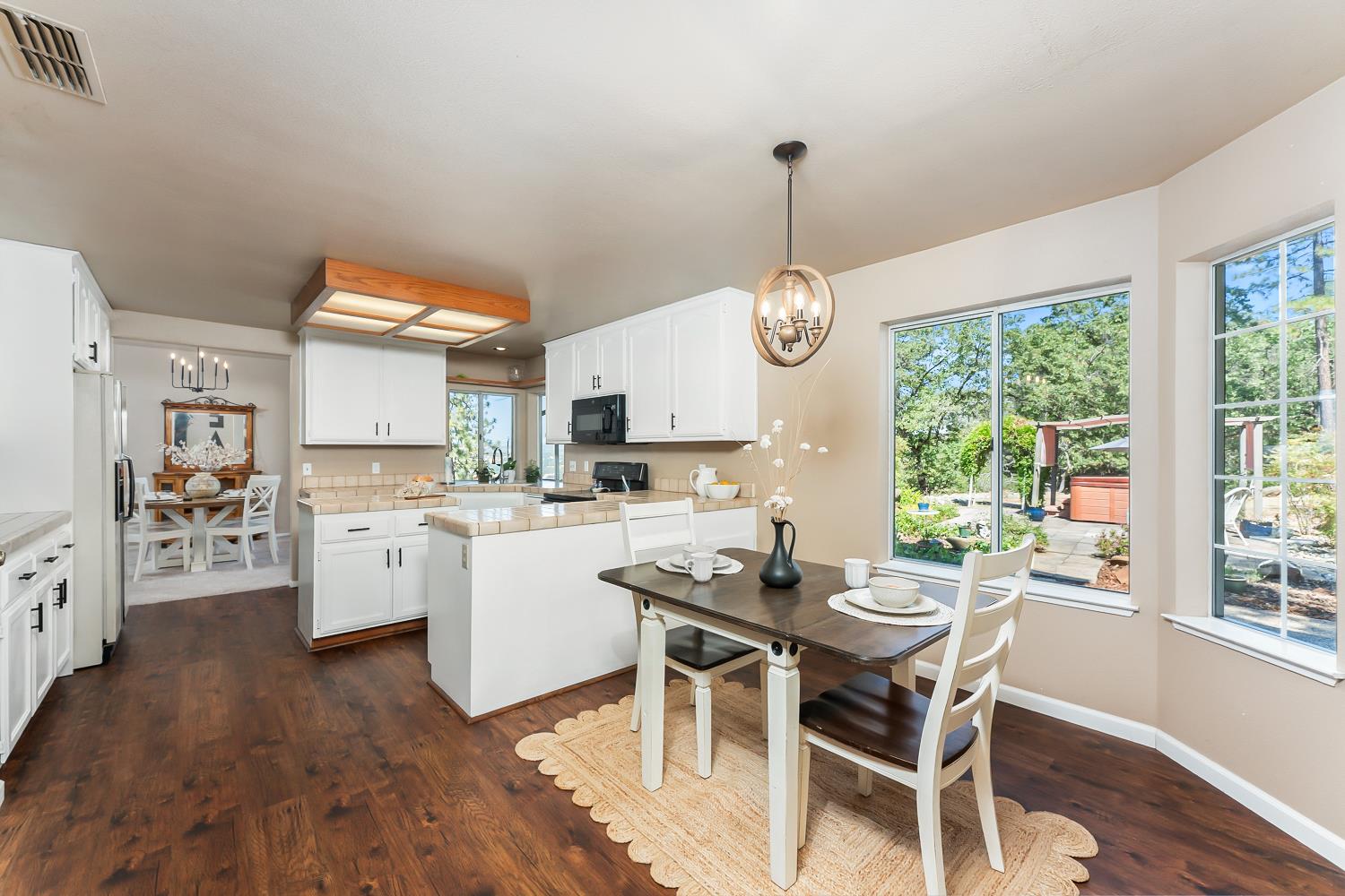 3472 See View Court Rescue, CA 95672 - Photo 11 of 37 a dining room with wooden floor a chandelier a wooden table and chairs