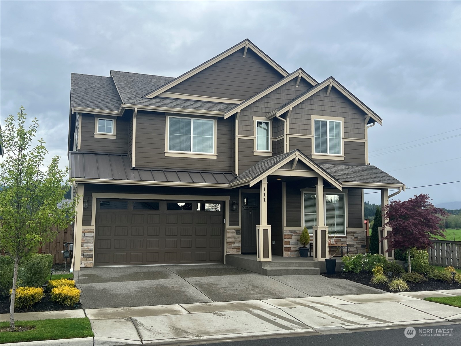a front view of a house with a garden and plants