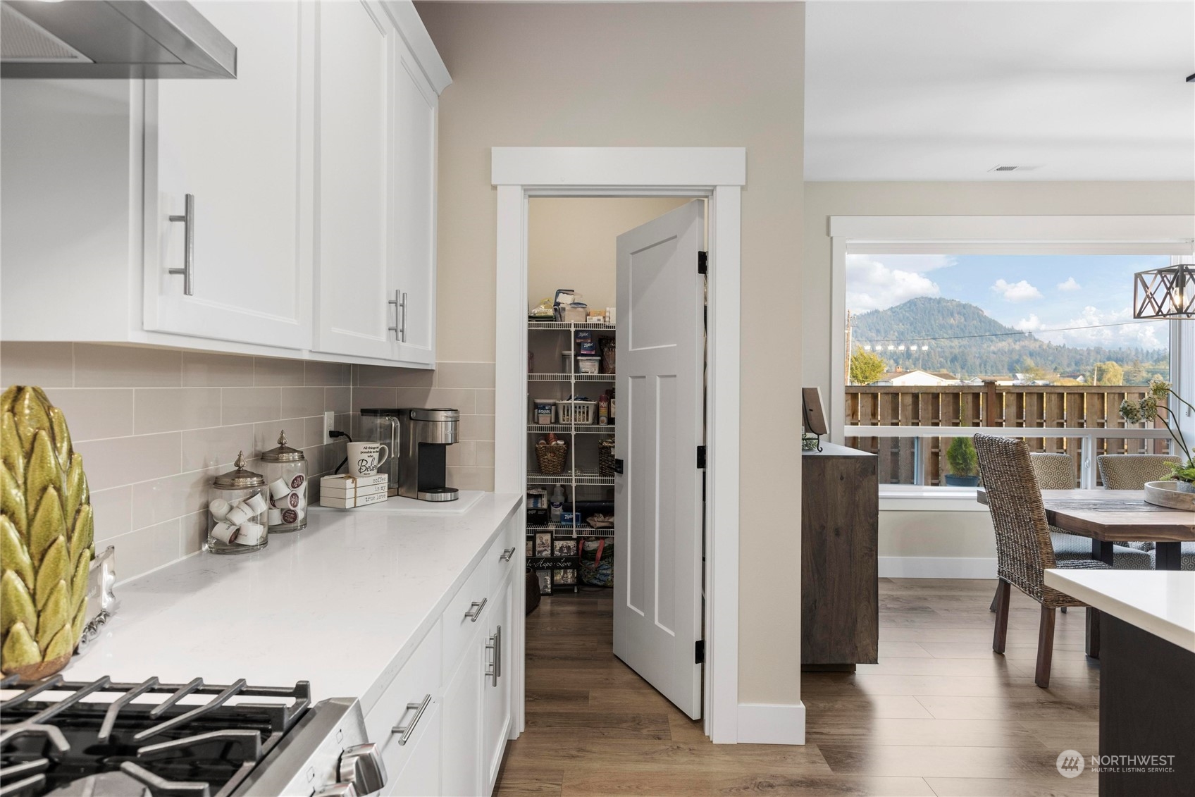 111 Love Drive Enumclaw, WA 98022 - Photo 11 of 34 a kitchen with stainless steel appliances a white table chairs and a wooden floor