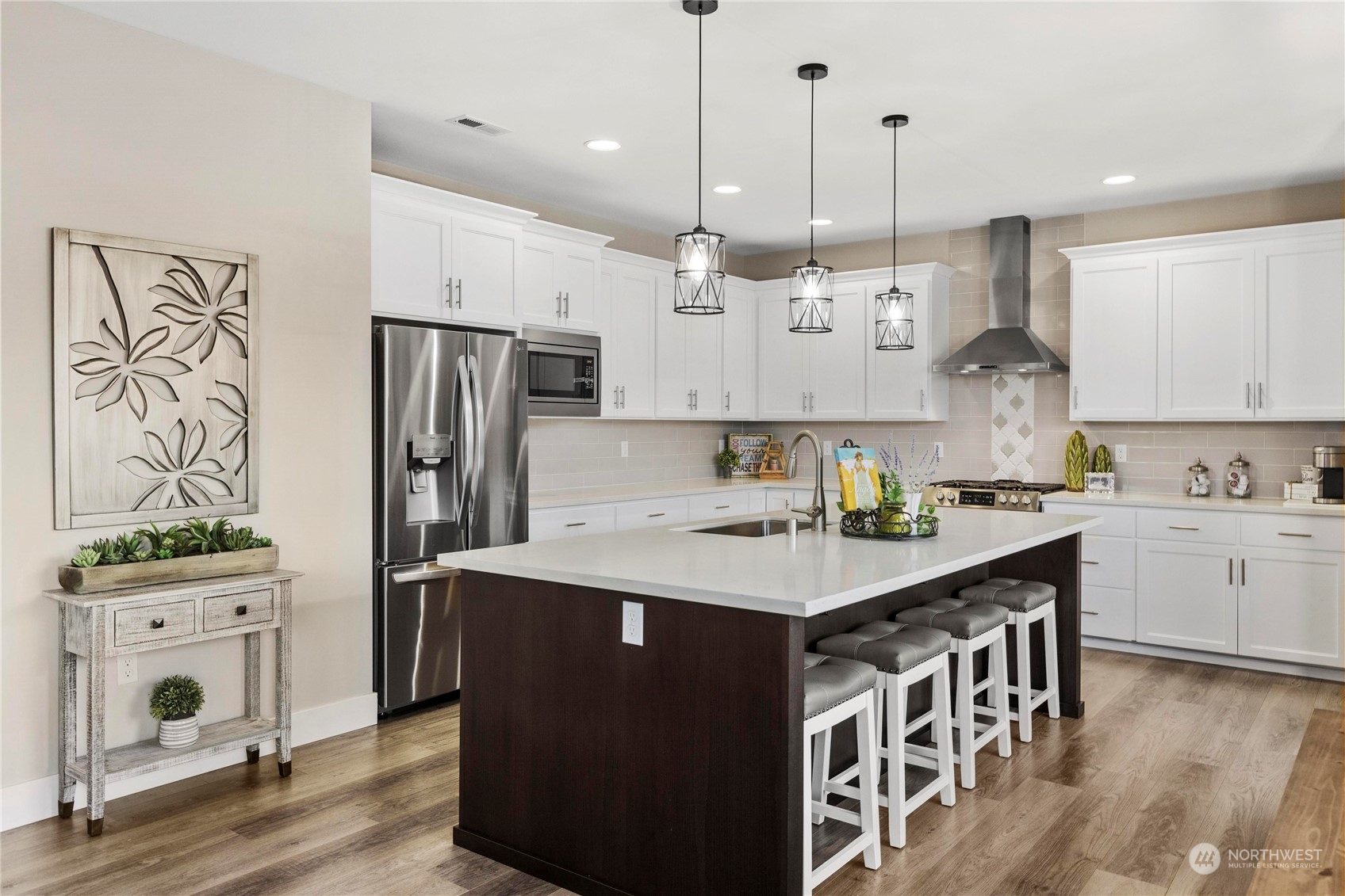 111 Love Drive Enumclaw, WA 98022 - Photo 7 of 34 a kitchen with stainless steel appliances kitchen island granite countertop a refrigerator a sink dishwasher a stove and white cabinets with wooden floor