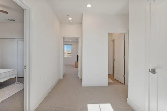 a view of a hallway with a livingroom and a bathroom