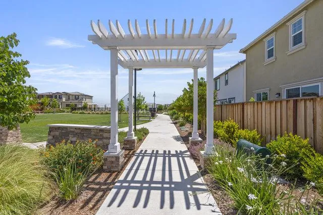 a view of a patio with table and chairs potted plants and floor to ceiling window