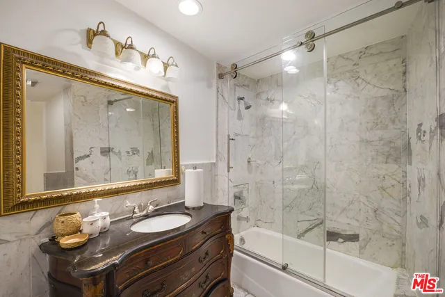 a bathroom with a granite countertop sink mirror and a bathtub