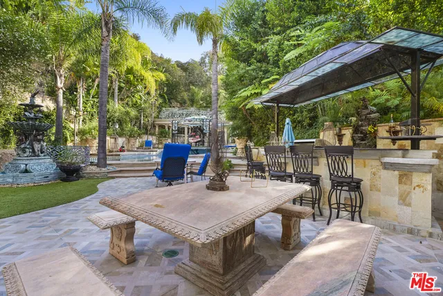 a view of a patio with table and chairs under an umbrella