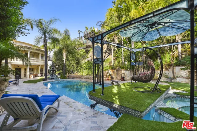 a view of a patio with table and chairs potted plants and large tree