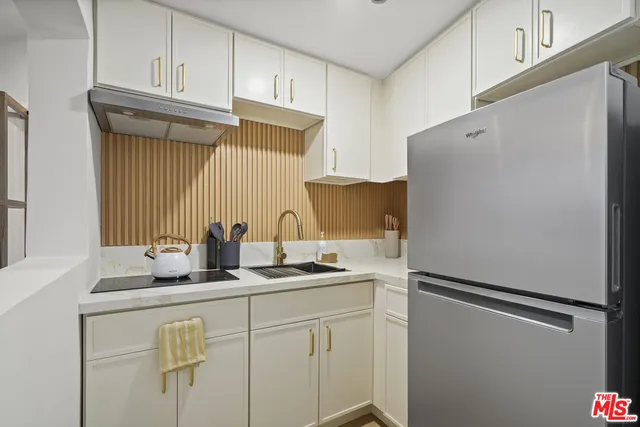a kitchen with stainless steel appliances white cabinets and a refrigerator