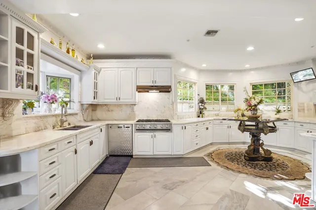 a kitchen with stainless steel appliances granite countertop a sink counter space cabinets and a large window
