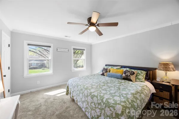 a bedroom with a bed a window and painting on the wall