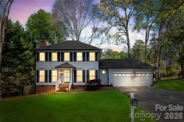a front view of a house with a yard and trees