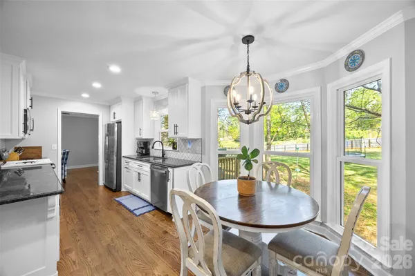 a dining room with stainless steel appliances granite countertop a table and chairs