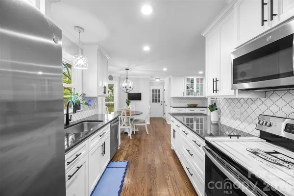 a kitchen with white cabinets and appliances