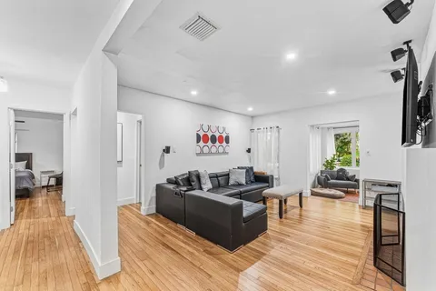 a living room with furniture and a wooden floor