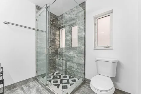 a bathroom with a toilet and a shower
