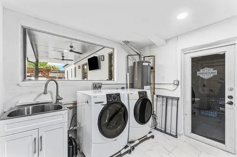 a utility room with sink dryer and washer