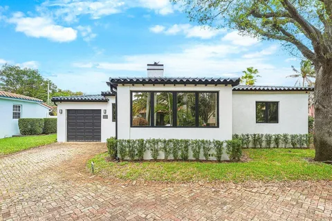 a front view of a house with a garden