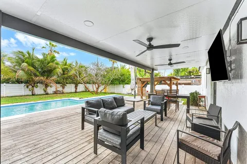 a living room with patio furniture and a floor to ceiling window