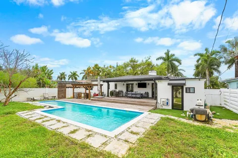 a view of a house with swimming pool and sitting area