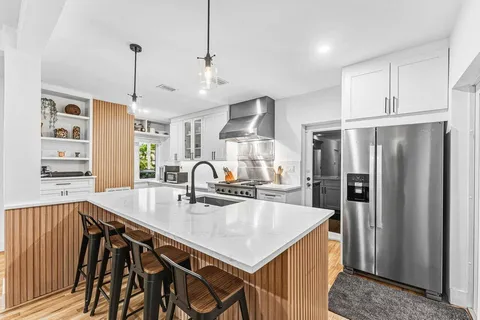 a kitchen with stainless steel appliances granite countertop a sink a refrigerator and a stove