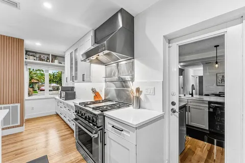 a kitchen that has a sink a stove and chairs