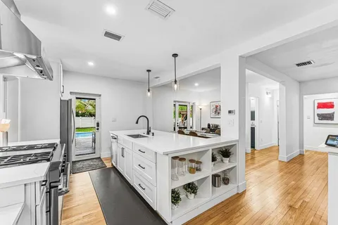 a large white room with a bed and a chandelier