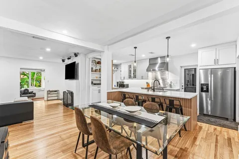 a large kitchen with kitchen island a large counter top stainless steel appliances and cabinets