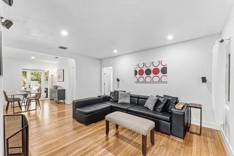 a media room with lots of chairs and wooden floor