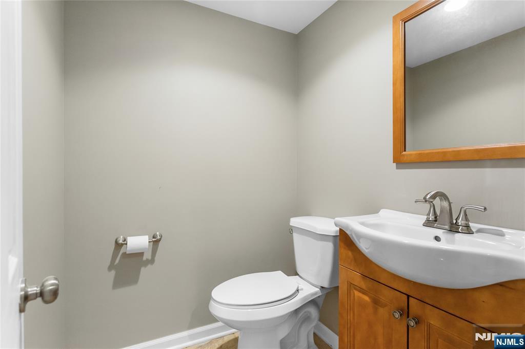 86 Reservoir Avenue Butler, NJ 07405 - Photo 24 of 32 a bathroom with a sink a toilet and a mirror