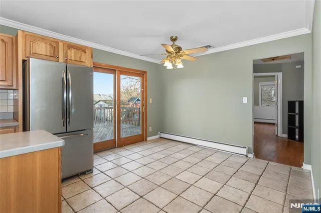 an empty room with fan and way to kitchen