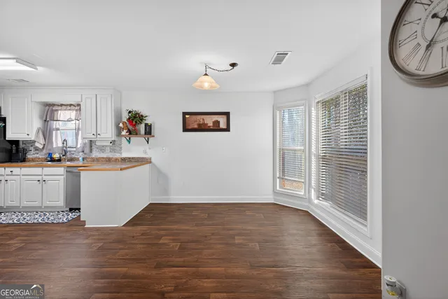 a view of a kitchen with wooden floor and a window