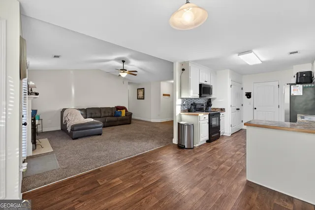 a living room with furniture and kitchen view