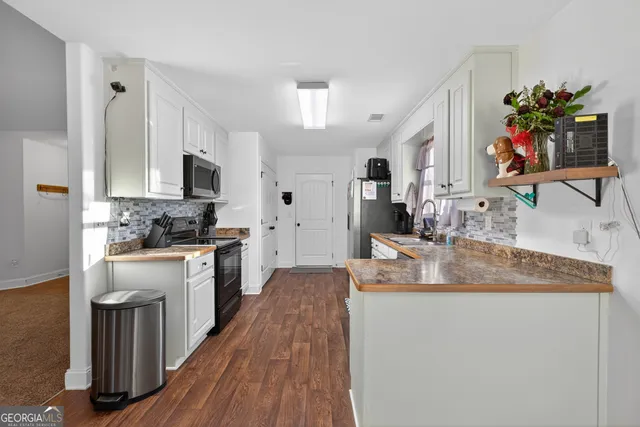 a kitchen with kitchen island granite countertop a sink stove and cabinets