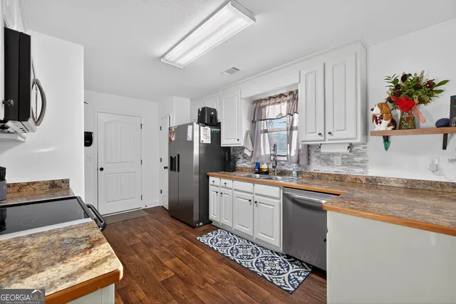 a kitchen with a refrigerator and a sink