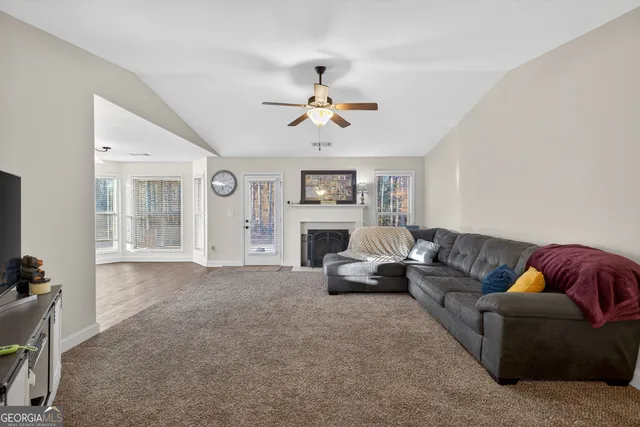 a living room with furniture a fireplace and a window
