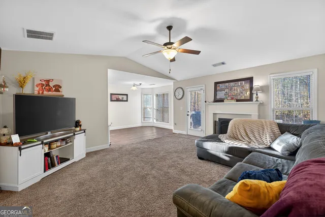 a living room with furniture a flat screen tv and a fireplace