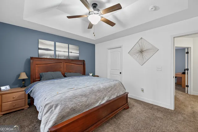 a bedroom with a bed and a ceiling fan
