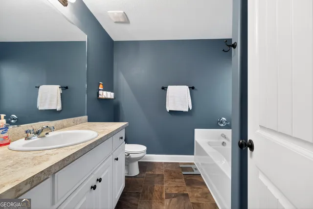 a bathroom with a sink toilet and mirror