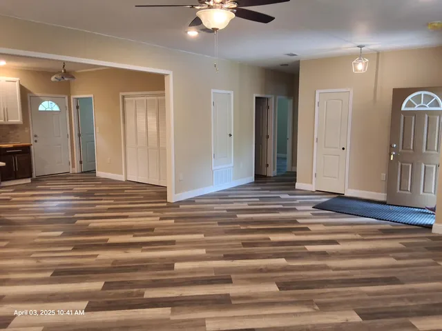 a view of a chandelier fan and wooden floor