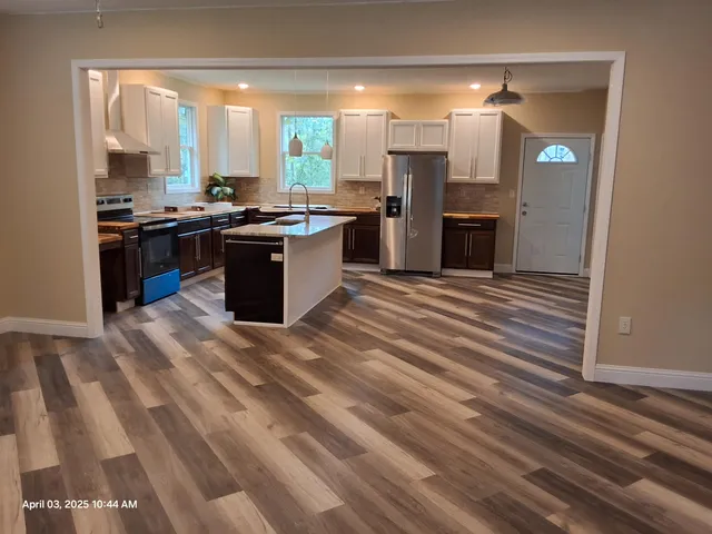 a large kitchen with stainless steel appliances kitchen island granite countertop a stove and a cabinets