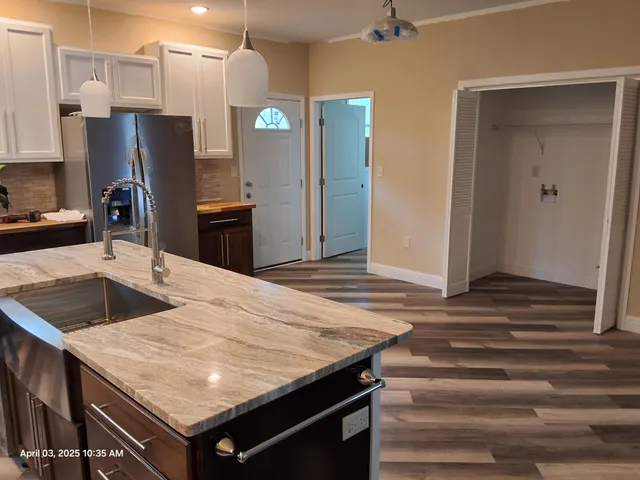 a kitchen with a wooden floor and refrigerator