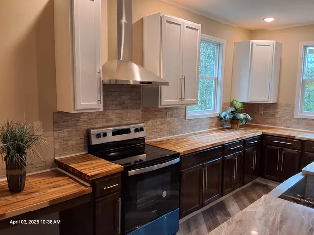 a kitchen with stainless steel appliances a stove a sink and a microwave