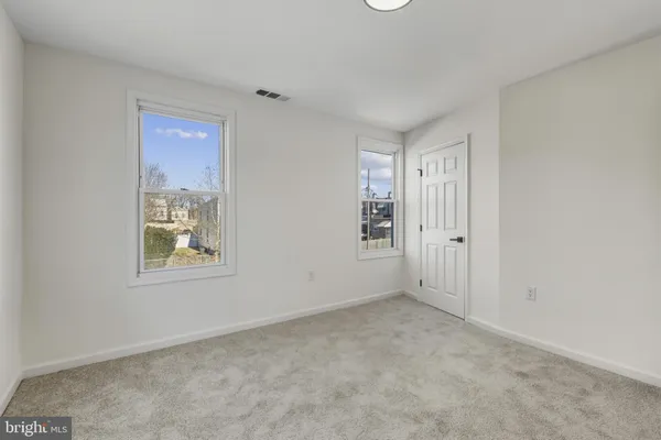 an empty room with windows and closet