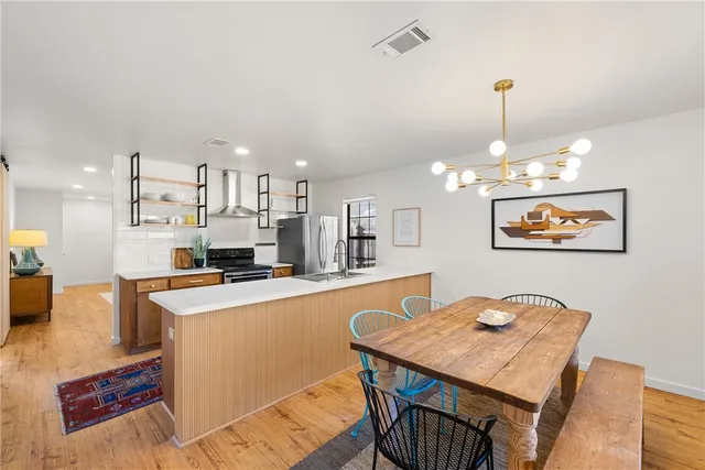 a kitchen with kitchen island a stove a table and chairs in it