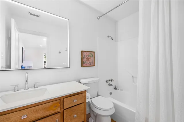 a bathroom with a granite countertop sink mirror vanity and toilet