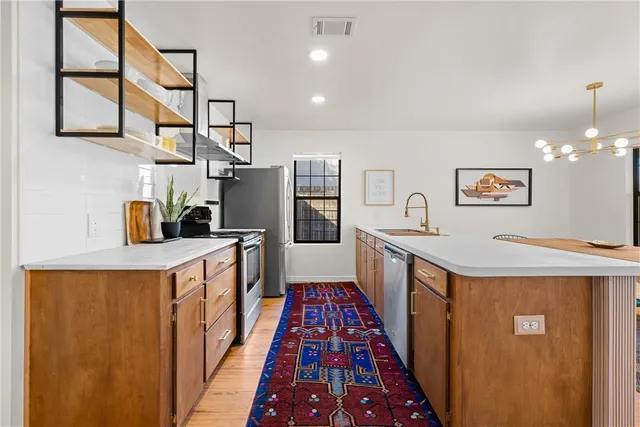 a kitchen with stainless steel appliances granite countertop a sink and a refrigerator
