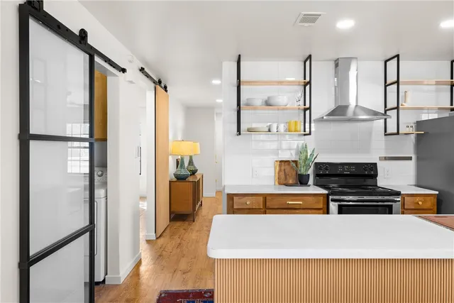 a large kitchen with stainless steel appliances granite countertop a refrigerator and a stove